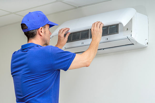 HVAC installing an AC unit on the wall